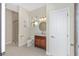 Charming bathroom with a wooden vanity, round mirror, and a glass enclosed shower at 5092 Ne 81St Blvd, Wildwood, FL 34785