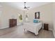Bright bedroom with wooden floors and charming decor, complemented by natural light and a cozy seating area at 5092 Ne 81St Blvd, Wildwood, FL 34785