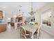 Bright dining room adjacent to kitchen features a wooden table, six chairs, and chandelier at 5092 Ne 81St Blvd, Wildwood, FL 34785