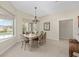 Bright dining room features a wooden table, six chairs, large window and neutral walls at 5092 Ne 81St Blvd, Wildwood, FL 34785