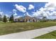Spacious white stucco home with a well-manicured lawn, dark trim, and beautiful landscaping in a sunny neighborhood at 5092 Ne 81St Blvd, Wildwood, FL 34785