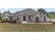 Charming white stucco home with dark trim, a well-maintained lawn, and a cozy, inviting curb appeal at 5092 Ne 81St Blvd, Wildwood, FL 34785