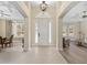 Bright foyer with tile flooring, an elegant white door, and views of the formal living and dining spaces at 5092 Ne 81St Blvd, Wildwood, FL 34785