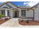 Inviting front entrance with a dark door, elegant stonework, lush landscaping, and a well-manicured lawn at 5092 Ne 81St Blvd, Wildwood, FL 34785