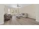 Cozy living room with hardwood floors, a large bay window, comfortable seating, and a neutral color palette at 5092 Ne 81St Blvd, Wildwood, FL 34785
