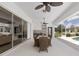 An elegant outdoor kitchen with a dining table and ceiling fans under a screened patio at 5092 Ne 81St Blvd, Wildwood, FL 34785