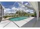 A stunning backyard pool area with lush green landscaping and beautiful blue skies at 5092 Ne 81St Blvd, Wildwood, FL 34785