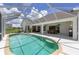 An overview of a beautiful screened pool, outdoor seating, and a full outdoor kitchen at 5092 Ne 81St Blvd, Wildwood, FL 34785