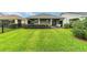 Expansive backyard with a covered patio, green lawn, and fencing, ideal for outdoor enjoyment at 5651 Nw 40Th Pl, Ocala, FL 34482