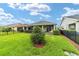 Beautiful backyard with a covered patio, lush lawn, privacy hedges, and black metal fencing at 5651 Nw 40Th Pl, Ocala, FL 34482