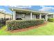 Well-manicured backyard featuring a covered patio, privacy hedges, and lush green grass at 5651 Nw 40Th Pl, Ocala, FL 34482