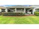 Charming backyard featuring a covered patio, manicured lawn, and privacy hedges at 5651 Nw 40Th Pl, Ocala, FL 34482