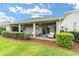 Lush backyard featuring a covered patio, well-maintained lawn, and privacy landscaping at 5651 Nw 40Th Pl, Ocala, FL 34482
