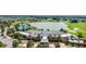 Aerial shot showcases a modern clubhouse with expansive grounds including a scenic lake and lush golf course at 5651 Nw 40Th Pl, Ocala, FL 34482