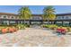 The community center features a stone paved patio with comfortable seating and lush landscaping with palm trees at 5651 Nw 40Th Pl, Ocala, FL 34482