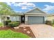 Charming single-story home with a brick driveway, well-manicured landscaping, and a two-car garage at 5651 Nw 40Th Pl, Ocala, FL 34482