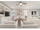 Bright living room with white furniture, ceiling fan, and built in shelving for storage at 5651 Nw 40Th Pl, Ocala, FL 34482