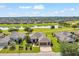 Aerial shot of a landscaped home with a lake view in a neighborhood with well-maintained lawns and landscaping at 6683 Sw 97Th Terrace Rd, Ocala, FL 34481