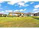 Lush backyard with a stone patio, outdoor dining set, and verdant green lawn under a bright sky at 6683 Sw 97Th Terrace Rd, Ocala, FL 34481
