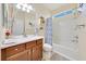 Bathroom features wood cabinets, a shower-tub combo, and a sunny window at 6683 Sw 97Th Terrace Rd, Ocala, FL 34481