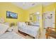 Bright bedroom with twin beds, yellow walls, and a mirrored closet at 6683 Sw 97Th Terrace Rd, Ocala, FL 34481