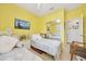 This bedroom features two twin beds, a closet with mirrored doors and yellow walls at 6683 Sw 97Th Terrace Rd, Ocala, FL 34481