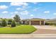 Inviting single-story home with a three-car garage, well-maintained lawn, and meticulously landscaped front yard at 6683 Sw 97Th Terrace Rd, Ocala, FL 34481