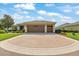 Single-story home with a three-car garage, well-maintained lawn, and patterned circular driveway at 6683 Sw 97Th Terrace Rd, Ocala, FL 34481