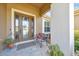 Cozy front entrance features a decorative glass door and a bench with patriotic cushions at 6683 Sw 97Th Terrace Rd, Ocala, FL 34481