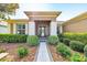 Charming front porch with decorative pillars, complemented by lush bushes and a stone pathway at 6683 Sw 97Th Terrace Rd, Ocala, FL 34481