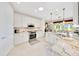 Bright kitchen with granite countertops, white cabinets, and stainless steel appliances at 6683 Sw 97Th Terrace Rd, Ocala, FL 34481