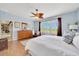 The bright main bedroom has hardwood floors, plantation shutters and a ceiling fan at 6683 Sw 97Th Terrace Rd, Ocala, FL 34481