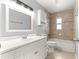 Bright bathroom featuring a single sink vanity, a large mirror, and a shower and bathtub combo with tiled walls at 6989 Se 52Nd Pl, Ocala, FL 34472