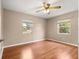 A bedroom with wood laminate flooring, two windows, and a ceiling fan at 6989 Se 52Nd Pl, Ocala, FL 34472