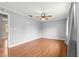 A bedroom featuring wood laminate flooring, a ceiling fan, neutral colored walls, and a view of the door at 6989 Se 52Nd Pl, Ocala, FL 34472
