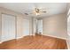 A bedroom with wood laminate flooring, a double door closet, and a ceiling fan at 6989 Se 52Nd Pl, Ocala, FL 34472