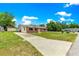 Brick home featuring a long driveway, and a spacious front yard with lush green grass at 6989 Se 52Nd Pl, Ocala, FL 34472