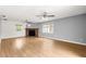 Bright living room features wood-look flooring, brick fireplace and natural light at 6989 Se 52Nd Pl, Ocala, FL 34472
