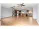 Spacious living room with wood floors, ceiling fans, and a view of the adjacent kitchen at 6989 Se 52Nd Pl, Ocala, FL 34472