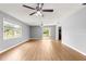 Open living room features wood-look flooring, a sliding glass door, and a large window at 6989 Se 52Nd Pl, Ocala, FL 34472