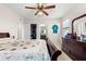 Spacious bedroom featuring a ceiling fan, closet, ensuite bathroom, and dresser with a large mirror at 8142 Sw 59Th Ave, Ocala, FL 34476