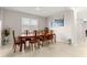 Dining area featuring a long wooden table, tile floors, and a large window at 8142 Sw 59Th Ave, Ocala, FL 34476
