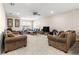 Open-concept living room featuring plush sofas, ceiling fan, and a large window for ample natural light at 8142 Sw 59Th Ave, Ocala, FL 34476