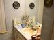 Bathroom featuring blue wallpaper, a sink, and many toiletries scattered around at 8321 Sw 108Th Place Rd, Ocala, FL 34481