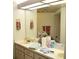 Well-lit bathroom featuring a double sink vanity and floral wallpaper accents at 8321 Sw 108Th Place Rd, Ocala, FL 34481