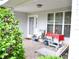 Inviting front porch with seating, decorated with plants, table, and offering a relaxing outdoor space at 8321 Sw 108Th Place Rd, Ocala, FL 34481