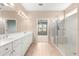 Bright bathroom with a double sink vanity, tile flooring, and a glass enclosed shower at 8961 Se 130Th Loop, Summerfield, FL 34491
