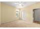 Bedroom with pale yellow walls, a window, carpet floors, and a ceiling fan at 8961 Se 130Th Loop, Summerfield, FL 34491
