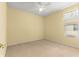 Sunny bedroom with pale yellow walls, a ceiling fan, neutral carpet, and a window at 8961 Se 130Th Loop, Summerfield, FL 34491