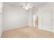 Unfurnished bedroom featuring neutral carpet, white walls, and a ceiling fan at 8961 Se 130Th Loop, Summerfield, FL 34491